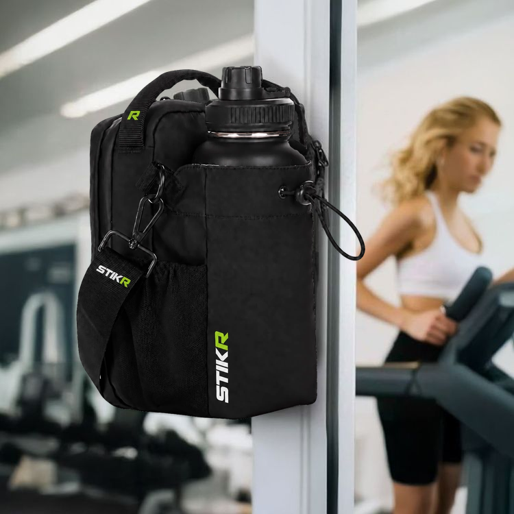 STIKR holding a bottle and phone on gym equipment