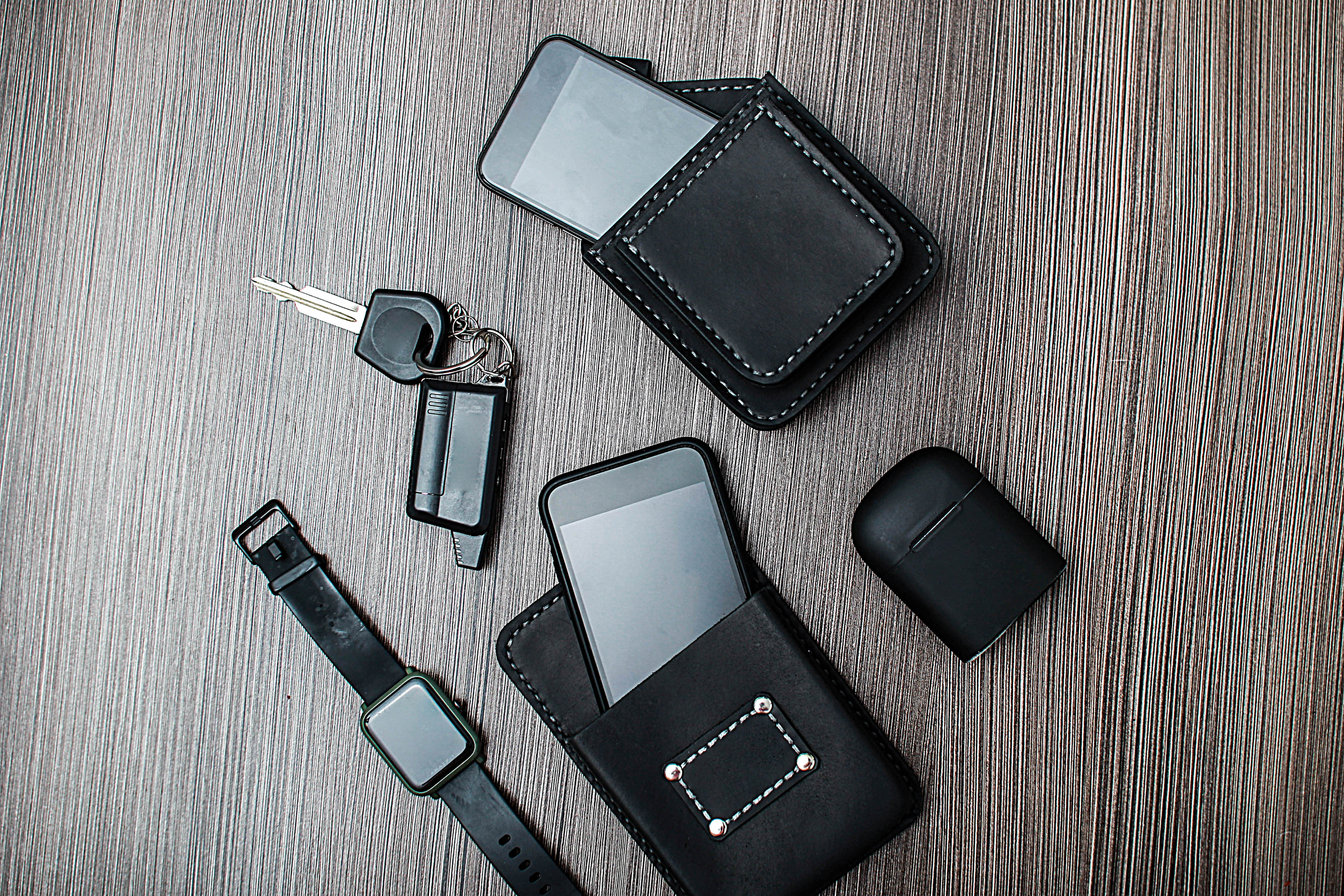 Phone, keys, wallet and AirPods on a table
